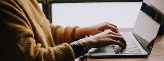 Banner zeigt Person, die am Laptop arbeitet