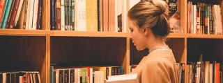 Banner zeigt Person, die vor Bücherregal steht